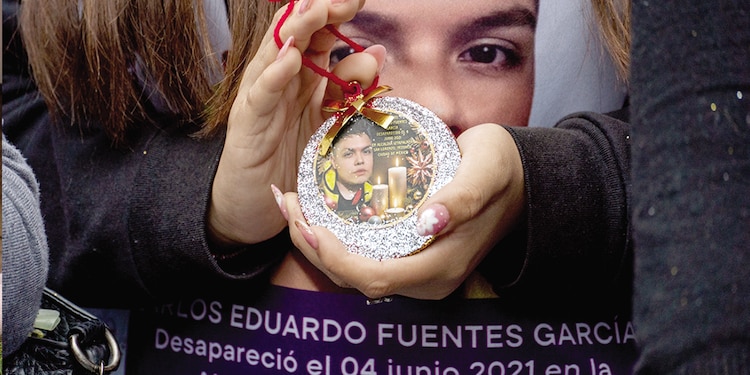 Una mujer sostiene una esfera con el rostro de José Fuentes, desaparecido desde 2021.