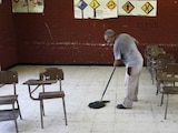 Una persona limpia un salón de clases