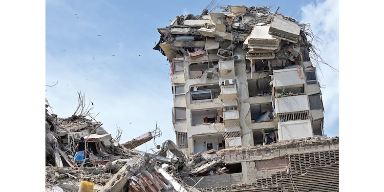 Personas buscan víctimas entre los
escombros de un edificio derrumbado, ayer.