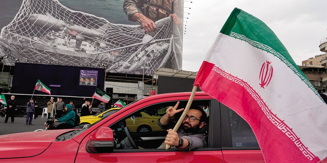 Un hombre porta una bandera iraní en Teherán.