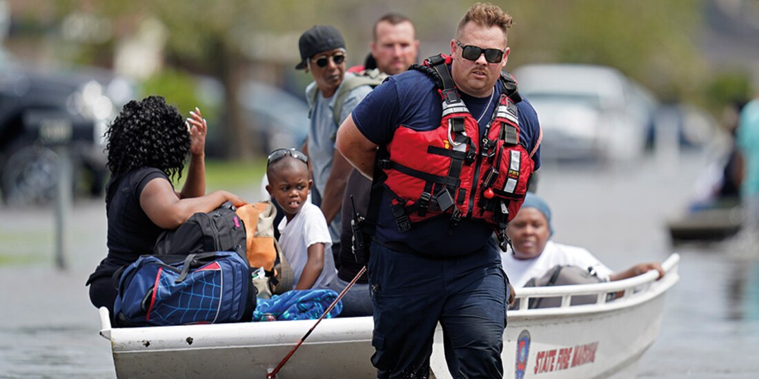 Rescatistas ayudan con lanchas a la población afectada en vecindarios de Louisiana, ayer.