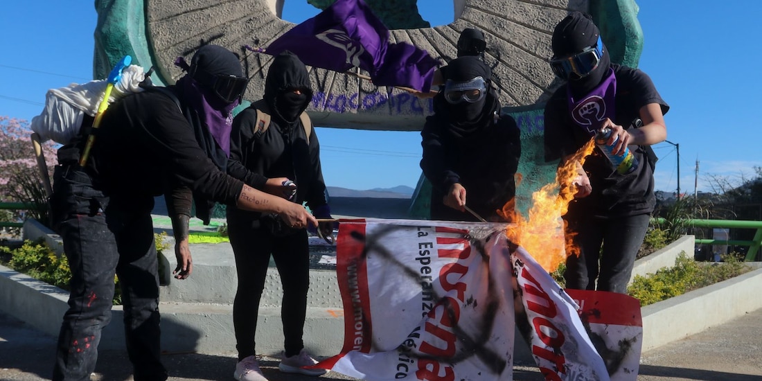 Encapuchadas queman un banderín de Morena, ayer, en Chilpancingo.