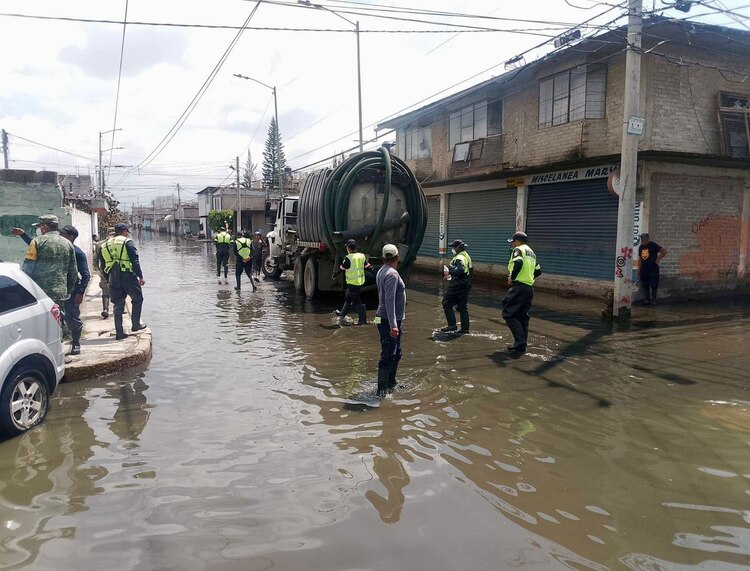 Trabajadores continúan con sus labores para reducir la inundación en Chalco, ayer, mientras que diversas instancias aumentan sus apoyos a los afectados.