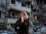 Una mujer llora frente a los escombros que dejó un ataque ruso en Kiev, Ucrania.