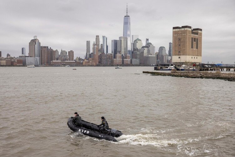 Un equipo de buzos del Departamento de Policía de Nueva York busca restos de un helicóptero turístico que se estrelló en la víspera en el río Hudson, en Jersey City, Nueva Jersey.