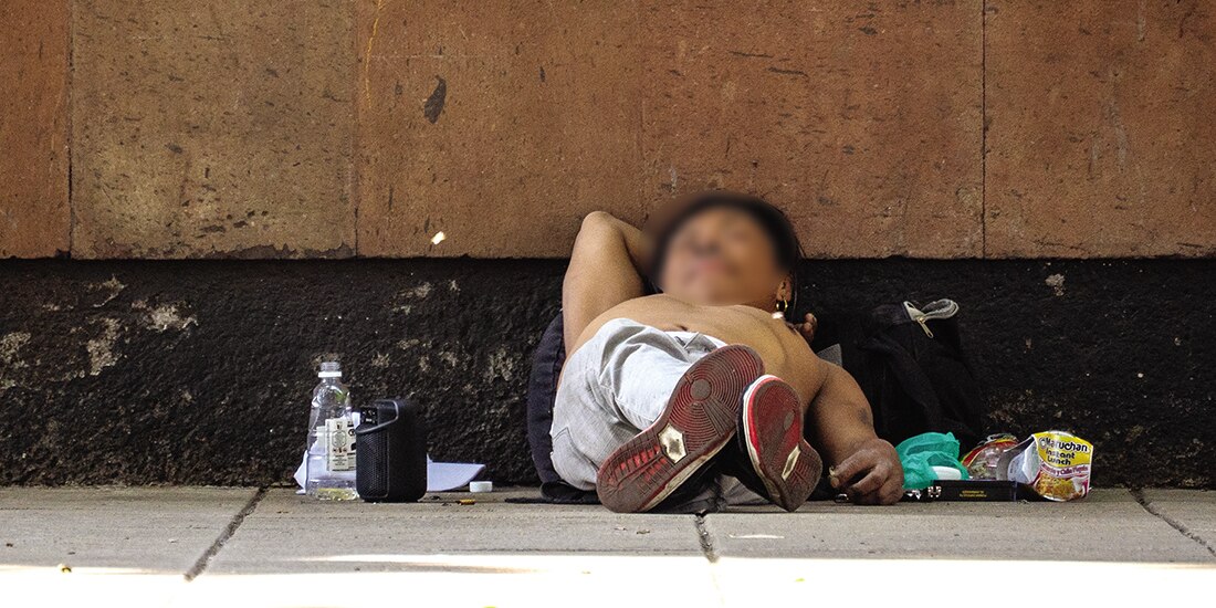 Un hombre en situación de calle duerme sin playera en una acera del Centro Histórico, pese a las bajas temperaturas, el pasado martes.