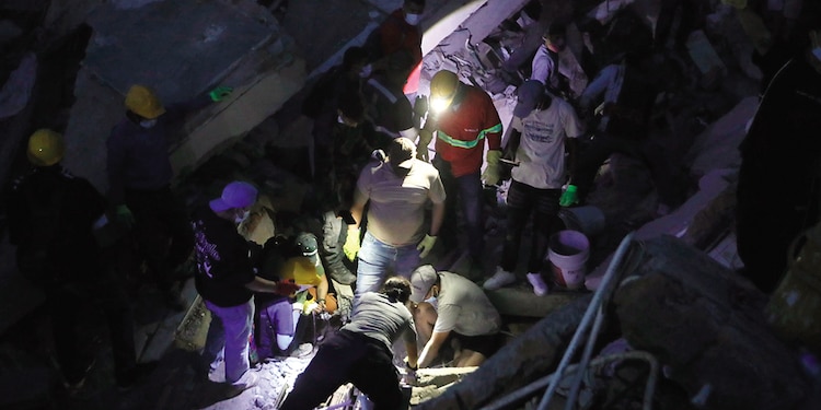Personas buscan entre los escombros tras el terremoto que azotó Cali, ayer.