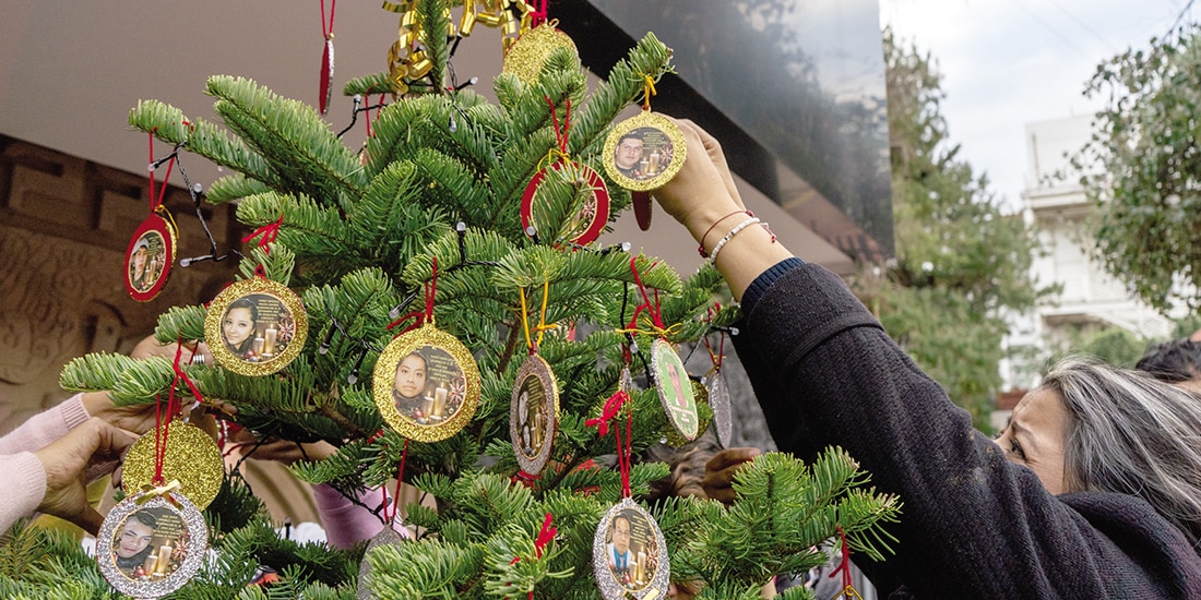 Madres buscadoras colocan las fotos de sus familiares en el pino ayer.