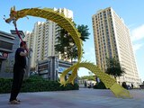 Un hombre ondea un dragón de tela ante el complejo residencial Evergrande Yujing Bay en Beijing, China.