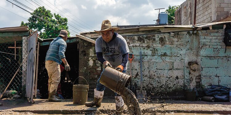 Vecinos apoyan a sacar el lodo de las casas con botes.