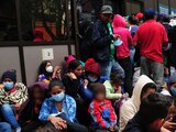 Migrantes esperan afuera de las instalaciones del INM pata poder ingresar a tramitar su tarjeta de visitante