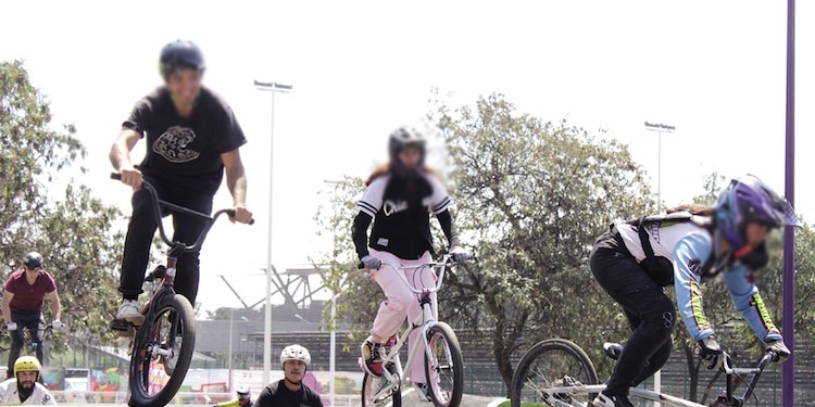 Jóvenes e infantes practican bicicleta y patines en la pista especial.