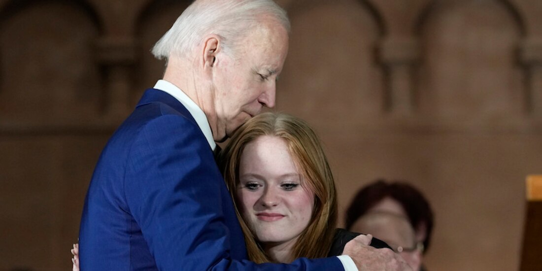 El presidente Joe Biden abraza a sobreviviente de la masacre en una ceremonia, ayer.