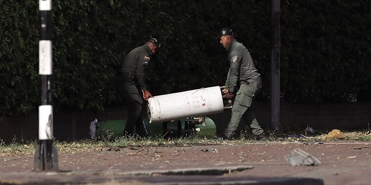 Policías cargan un cilindro.