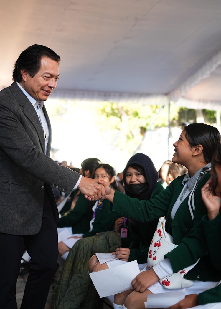 Mario Delgado, titular de la SEP, saluda a una estudiante.