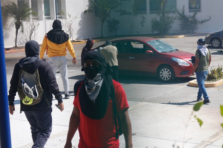 Encapuchados atacan las instalaciones de la FGE de Guerrero lanzando petardos y bombas molotov, y quemaron vehículos que estaban en el lugar, ayer.