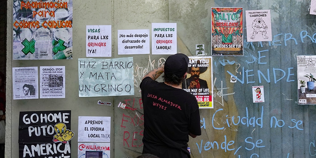Un hombre coloca un cartel en contra de la gentrificación, el 4 de julio.