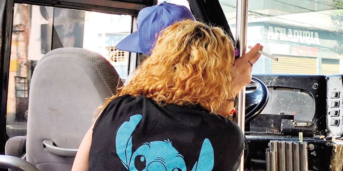 El conductor de una unidad, ayer, con una mujer como acompañante y fumando.