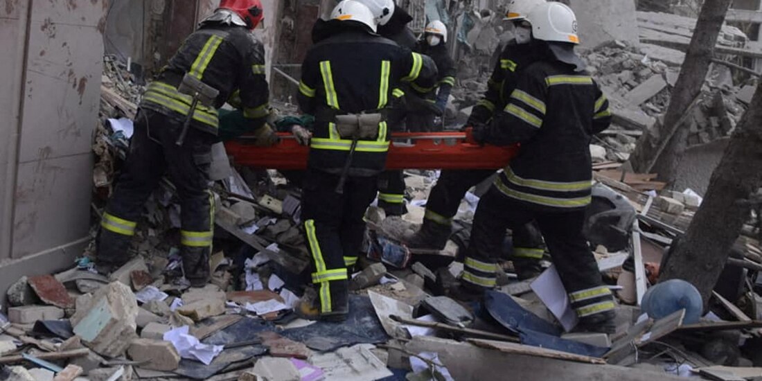 Rescatistas trasladan a víctimas luego del impacto de un misil, ayer, contra un edificio de gobierno en Mikolaiv.