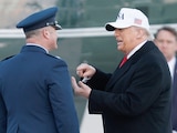 EL PRESIDENTE Trump (der.) conversa con un mando de la Fuerza Aérea antes de abordar el Air Force One, ayer.
