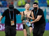 Elementos de seguridad sacan de la cancha a una espontánea que ingresó al campo durante el partido de la Eurocopa entre Finlandia y Bélgica en San Petersburgo.