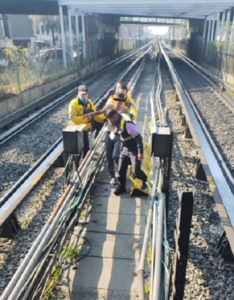 Personal de seguridad aparta al hombre de las vías del Metro, este martes
