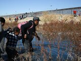 Una familia de migrantes cruza el río Bravo para llegar a EU, desde Ciudad Juárez, el 27 de diciembre.