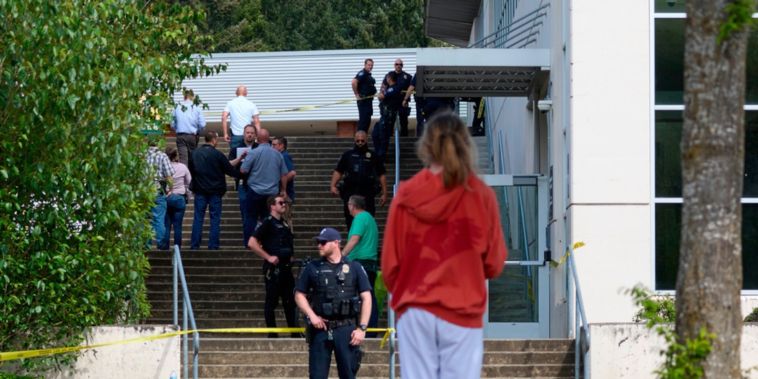 Un estudiante observa a agentes de la Policía de Tacoma luego de que varias personas resultaron heridas en un apuñalamiento masivo en la Escuela Secundaria Foss, en Tacoma, Washington.