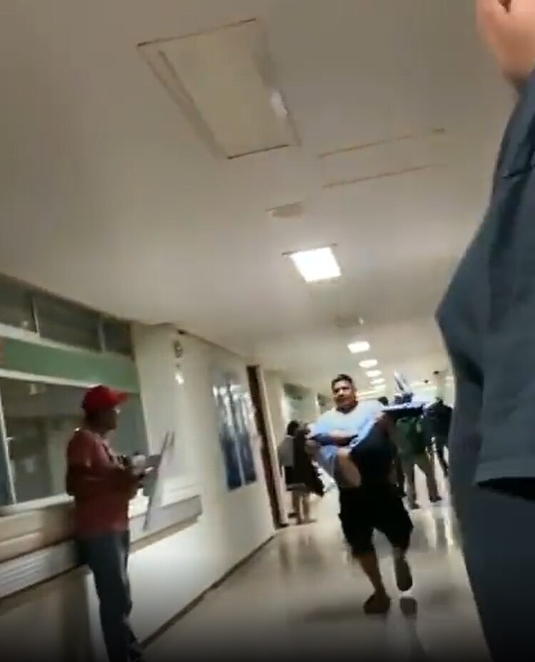 Un padre llevaba en brazos a su hija, para que le dieran atención médica tras ser intoxicada con presunta cocaína, el sábado.