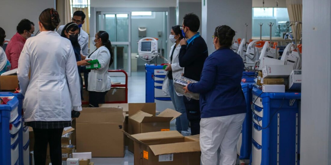 Personal que trabajará en el hospital revisa los componentes de cada cama para proceder a armar las pocas que faltan.