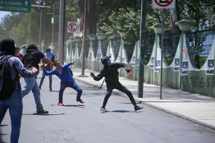 Los manifestantes lanzaron piedras, cohetones encendidos y petardos a elementos de la SSC y del Ejército, la tarde del viernes.