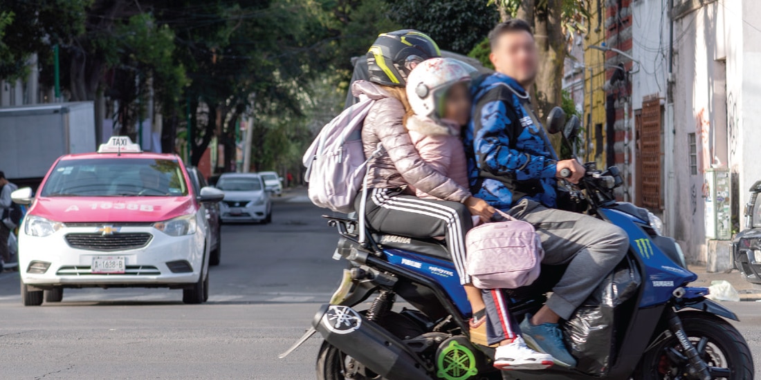 DOS ADULTOS, uno sin casco, viajan con una niña en una motoneta, el 31 de agosto