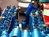 Un camión cargado con varios cilindros azules de gas en una jornada de trabajo