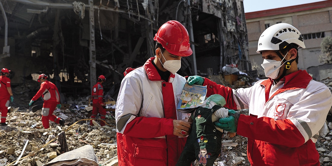 RESCATISTAS sostienen una muñeca, después de un ataque en Teherán, ayer.