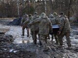 Soldados ucranianos trasladan el cuerpo de un combatiente para darle el último adiós.