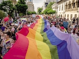Personas portan una bandera del arcoíris en Bucarest el 7 de junio de 2025.