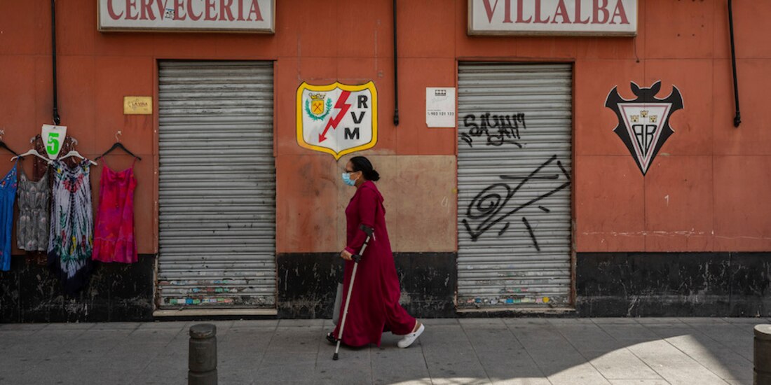 Una residente de Vallecas camina frente a un comercio cerrado en ese barrio, ayer.
