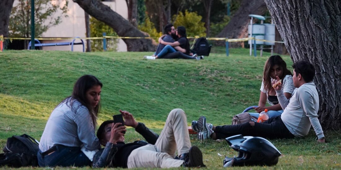 Parejas de enamorados disfrutan de la tarde en los pastos del Centro Nacional de las Artes.