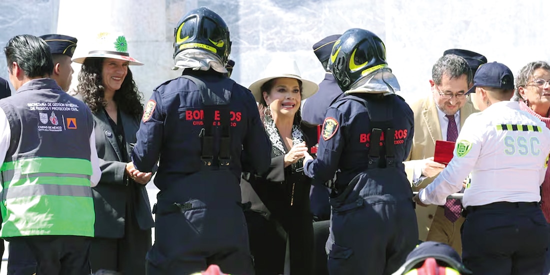 Clara Brugada Molina (c.), jefa de Gobierno, entregando reconocimiento a bomberos de la CDMX, el viernes.