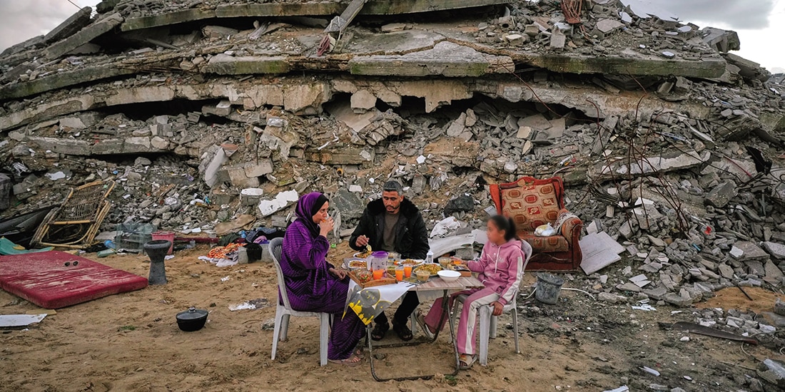Una familia gazatí rompe el ayuno en el Ramadán entre escombros, el 24 de febrero.