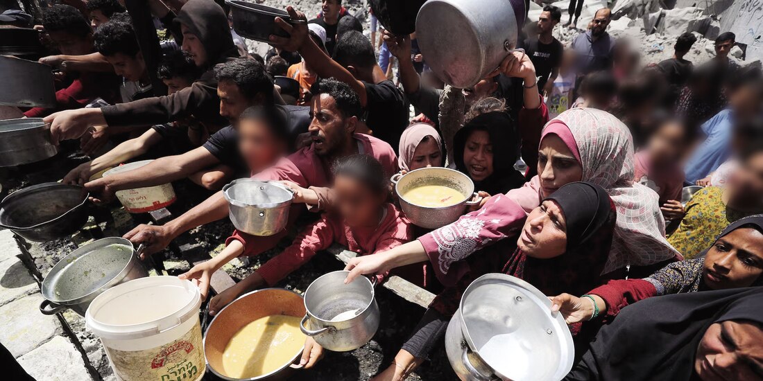 Palestinos esperan recibir comida preparada por una cocina benéfica en Jabalia, en el norte de la Franja de Gaza, ayer.