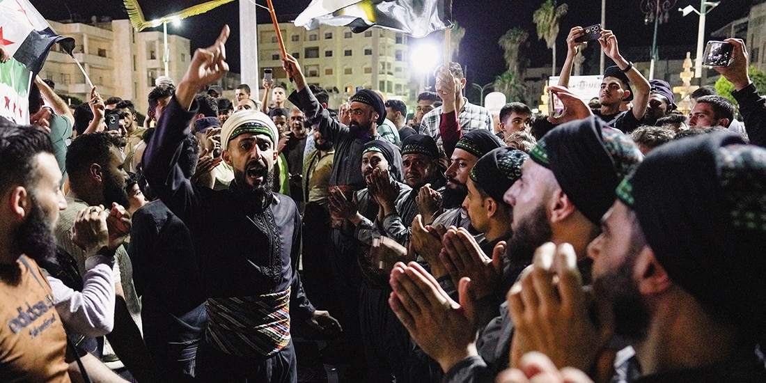 Personas celebran después de la sentencia a muerte a Bashar al Asad, ayer.