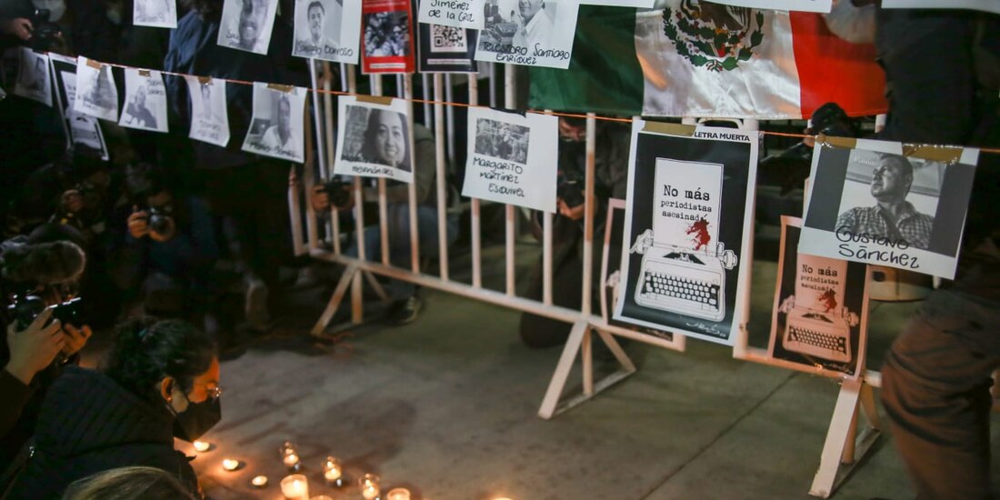Periodistas ponen veladoras ante las imágenes de colegas asesinados en años recientes.