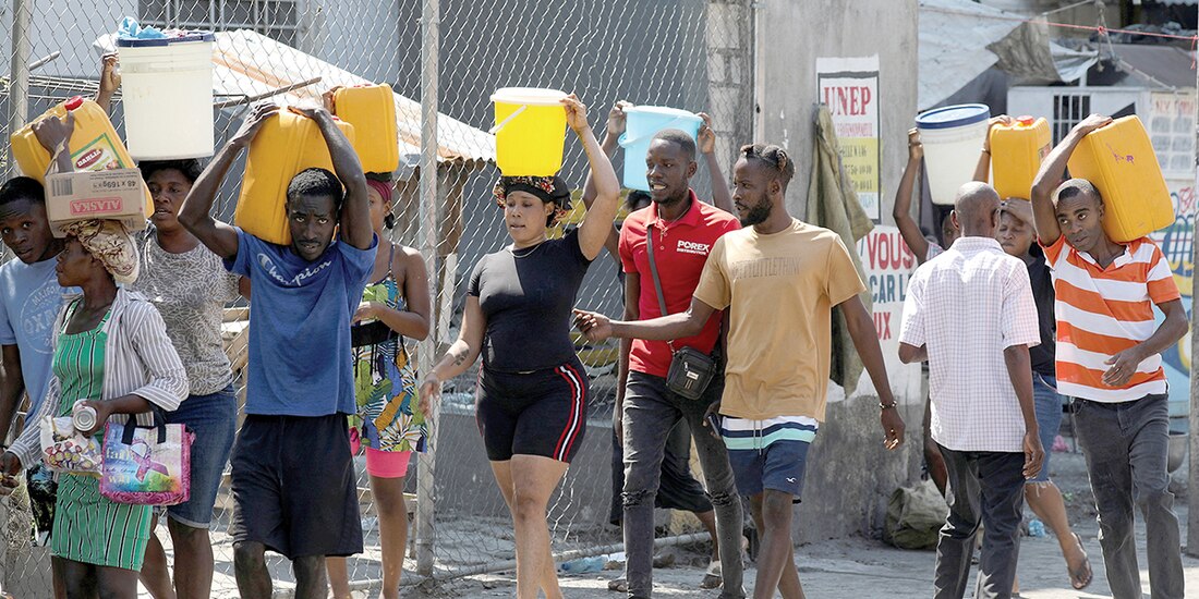 Habitantes de Puerto Príncipe cargan agua en cubetas y contenedores, el pasado 12 de marzo.