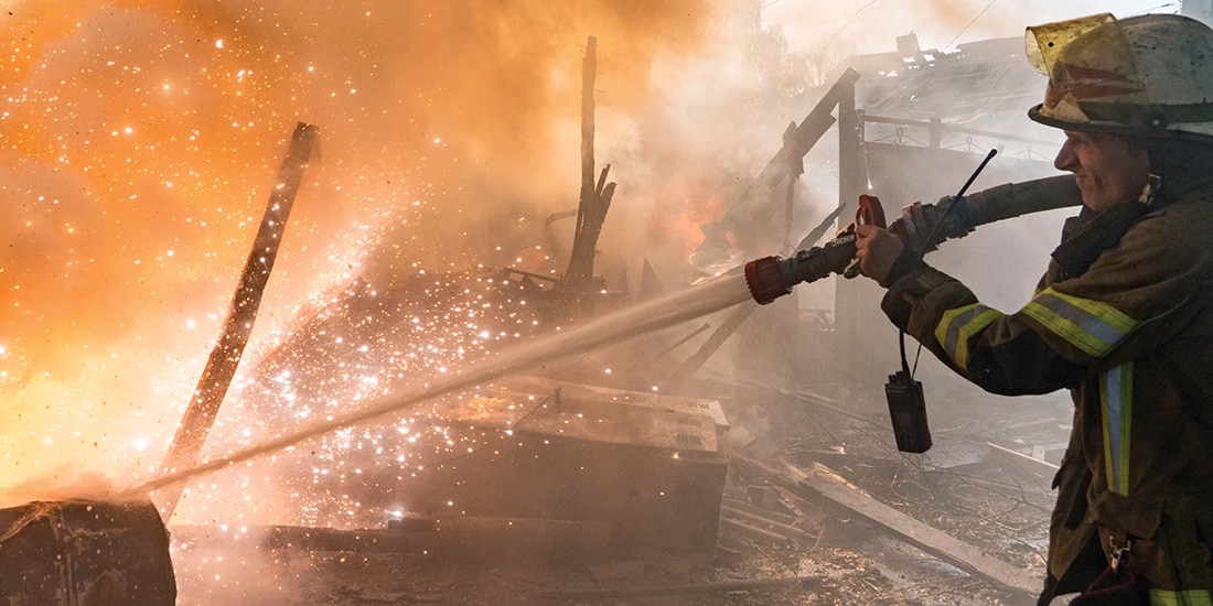 UN BOMBERO trabaja para apagar el fuego en viviendas tras un ataque ruso en Járkov, ayer.