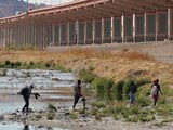 Un grupo de migrantes cruza corriendo el Río Bravo para ingresar a Estados Unidos