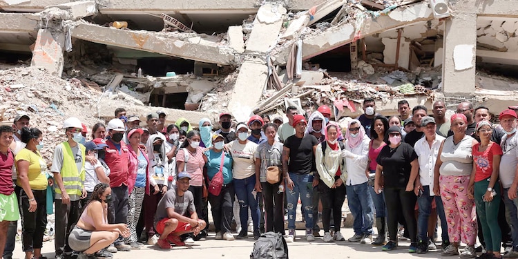 GENTE MIRA mientras socorristas participan en labores de rescate en La Guaira, ayer.