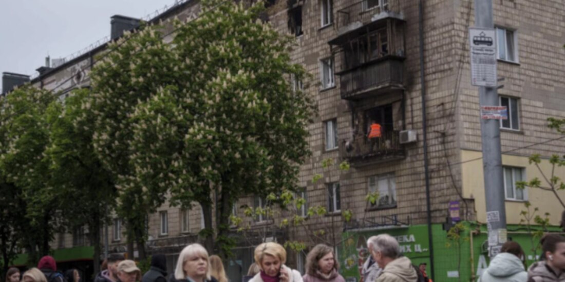 Un trabajador despeja escombros de un balcón en un edificio residencial dañado por un ataque ruso en Kiev, ayer.