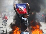 Una persona sostiene una bandera de Haití durante una protesta