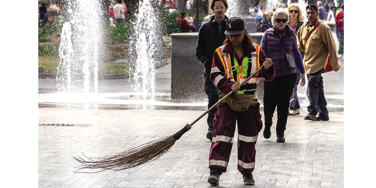 Una empleada barre la Alameda Central, en la alcaldía Cuauhtémoc.